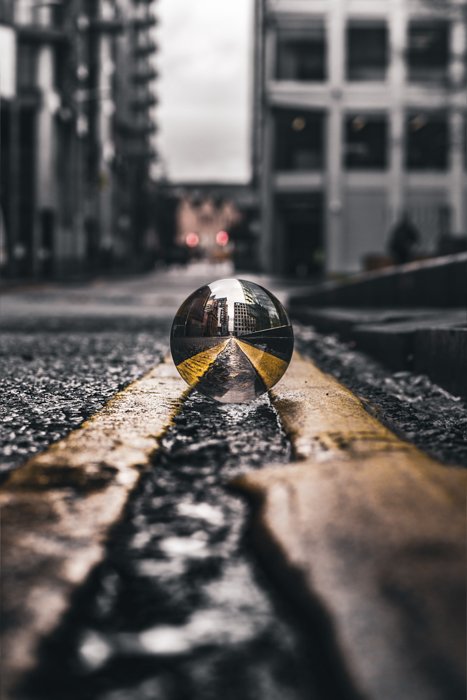 Leading lines reflected through a crystal ball on a city street