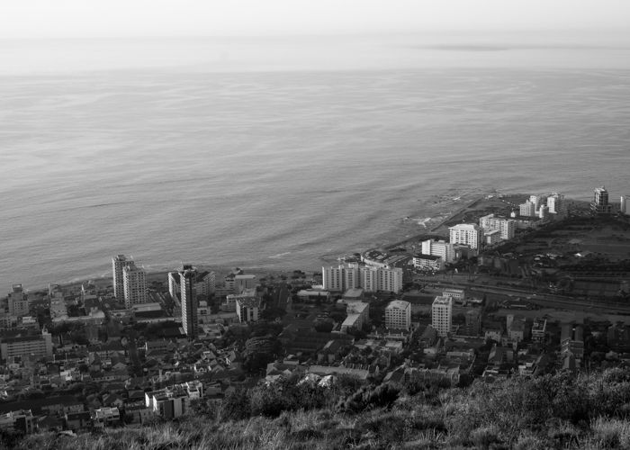 Uma fotografia aérea a preto e branco de uma cidade costeira.