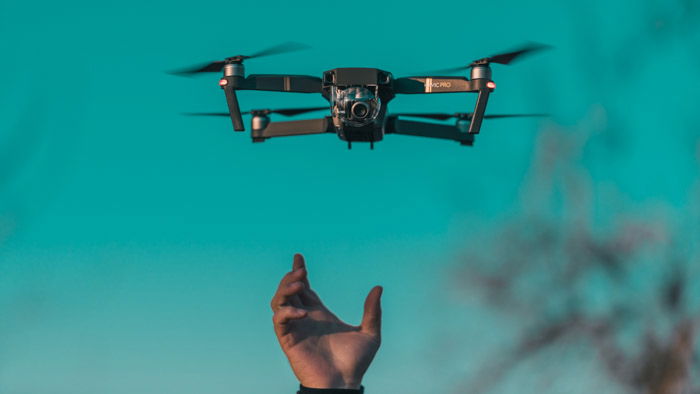 A hand releasing a drone 