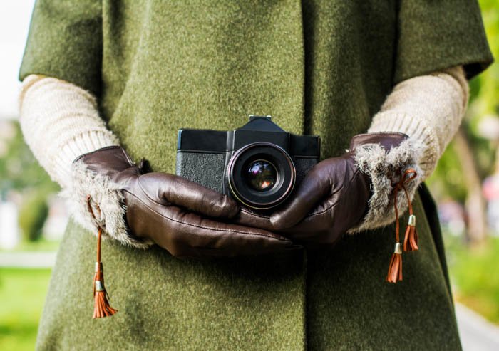 Winter photography gloves with firm grip holding a camera