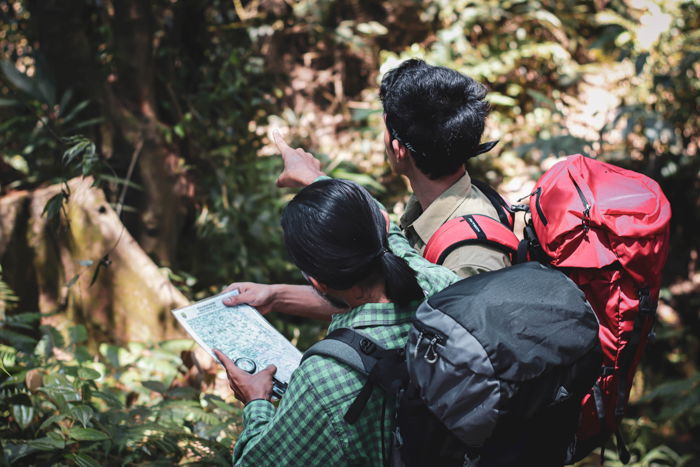 Uma imagem de dois homens na selva, olhando para um mapa.