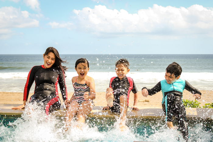 Family photos of 4 children playing in the ocean