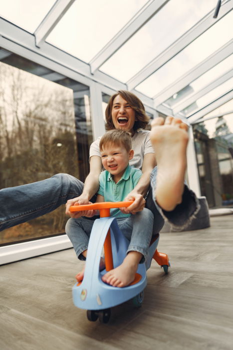 family portrait poses mother and son on toy bicycle