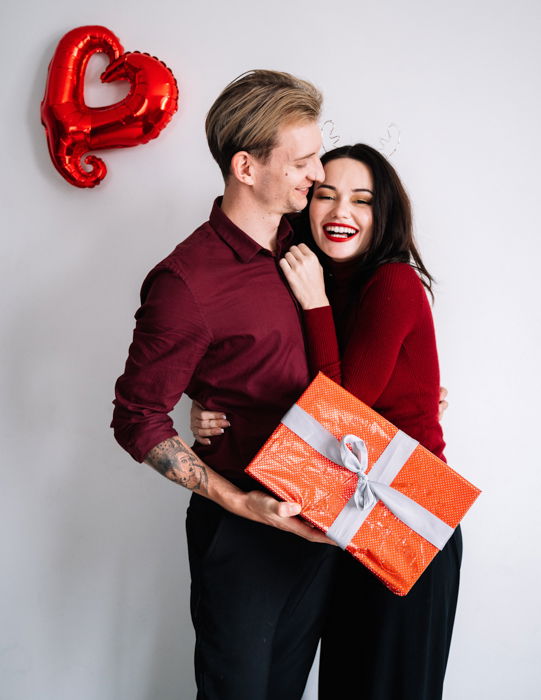 Image of a cute couple on Valentine's day holding a gift