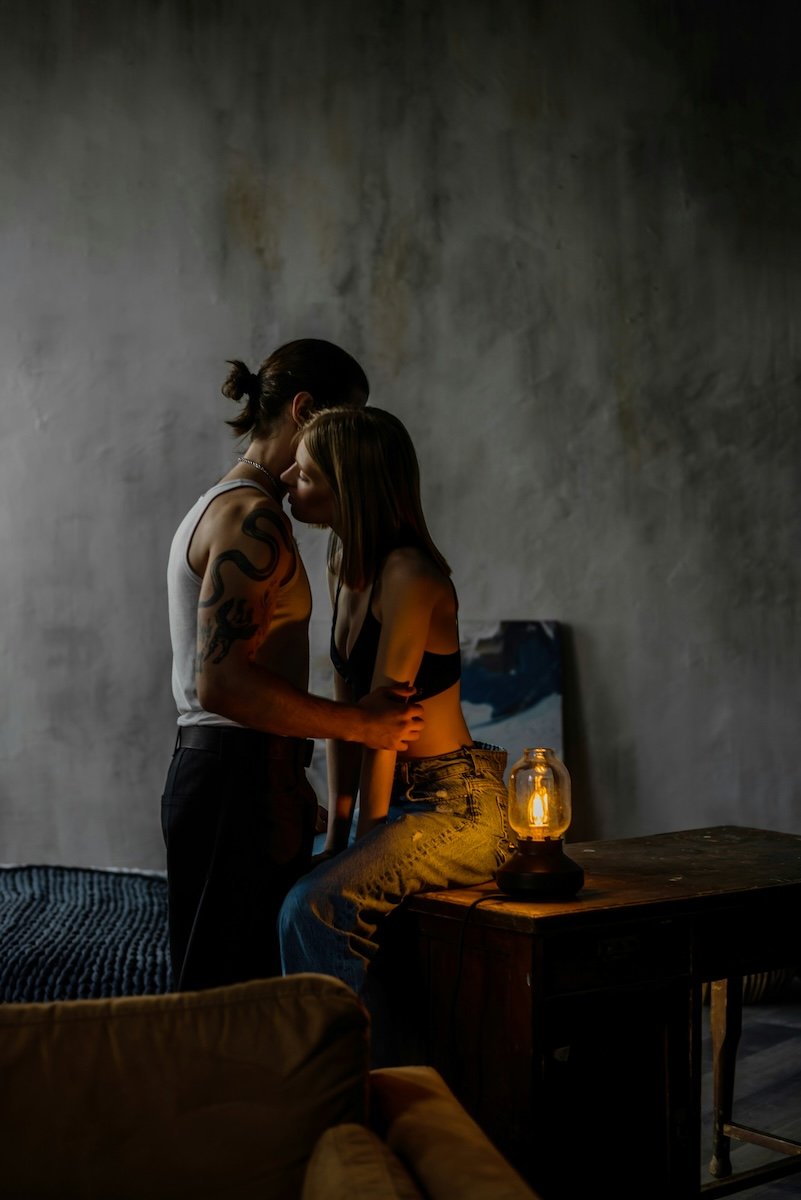 A couple embracing in a low-lit room as a Valentines day photoshoot idea