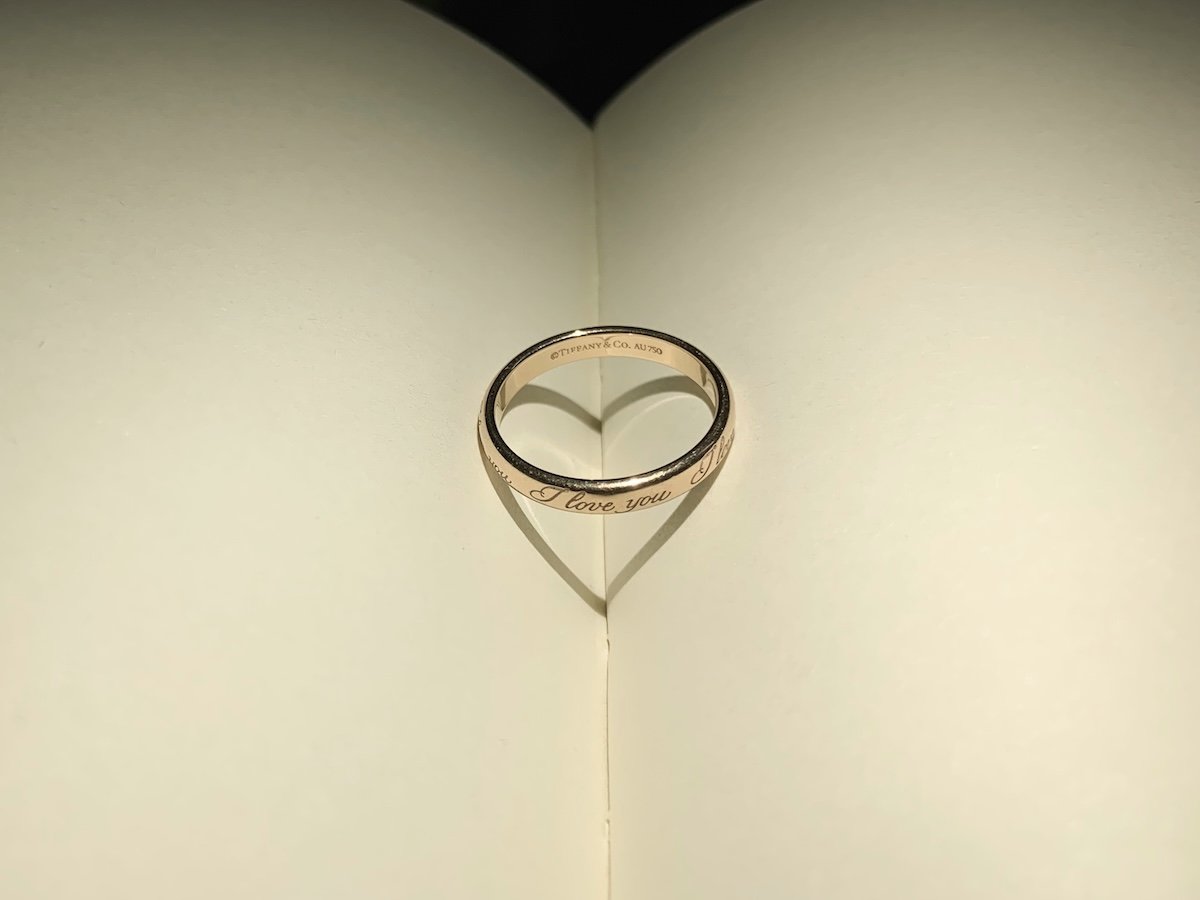 A ring casting a heart shadow on paper as a Valentines day photoshoot idea