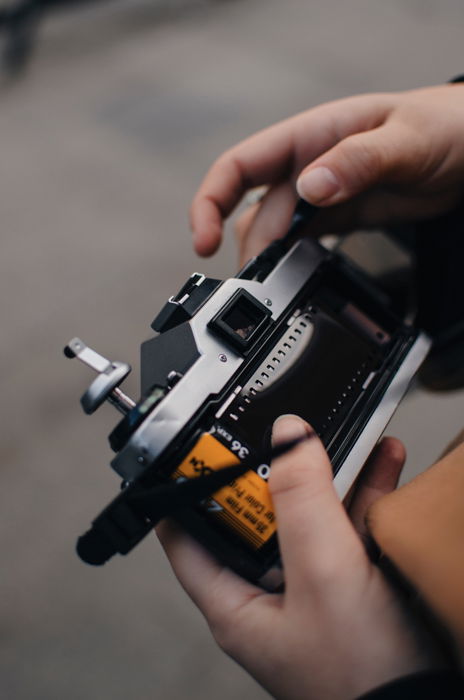 A man loading a roll of 35mm film into his analog camera