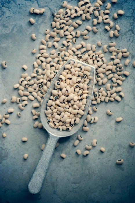 An overhead product photo of a small trowel filled with lentils