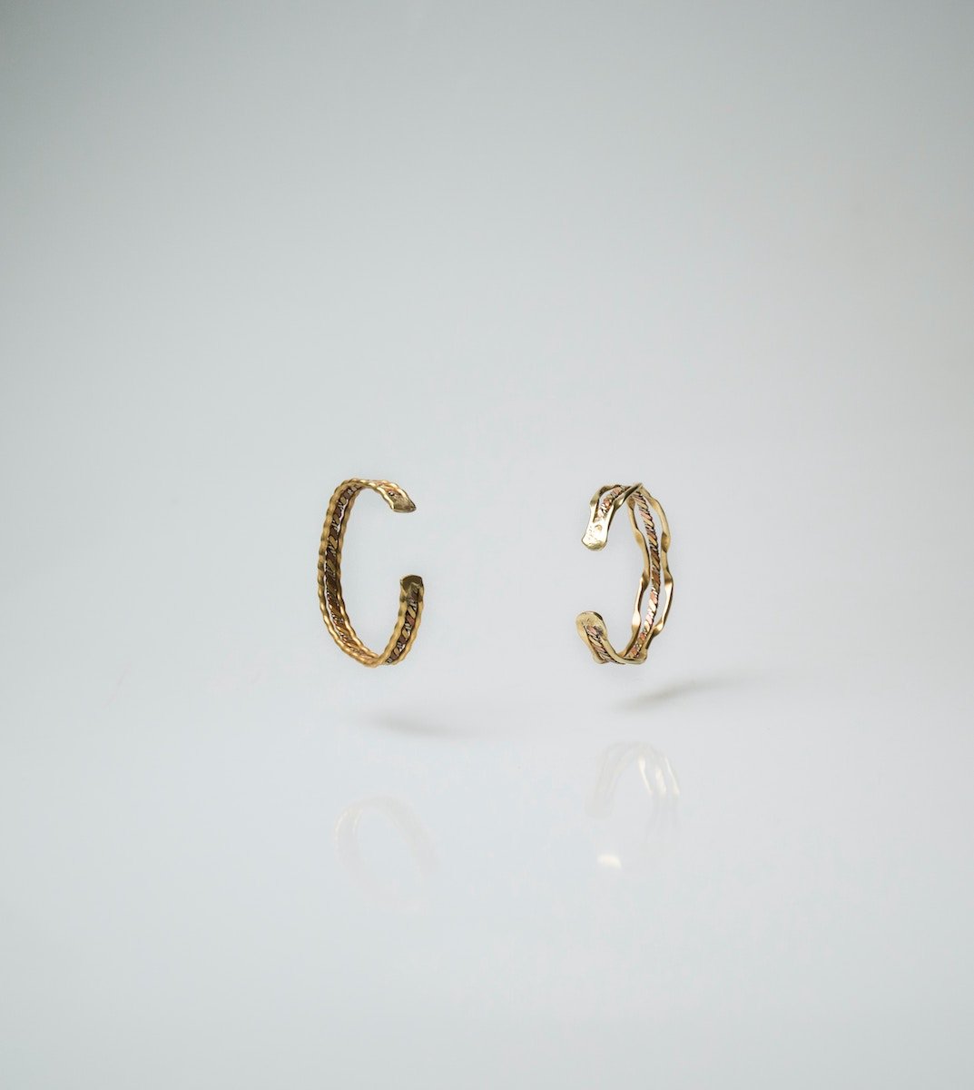 A DIY product photo of gold earrings over a white background