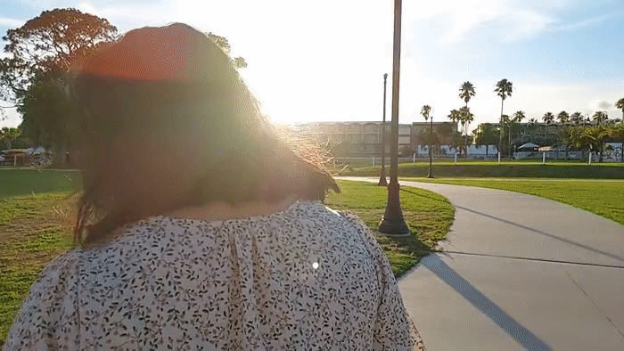 Camera following woman walking at the park