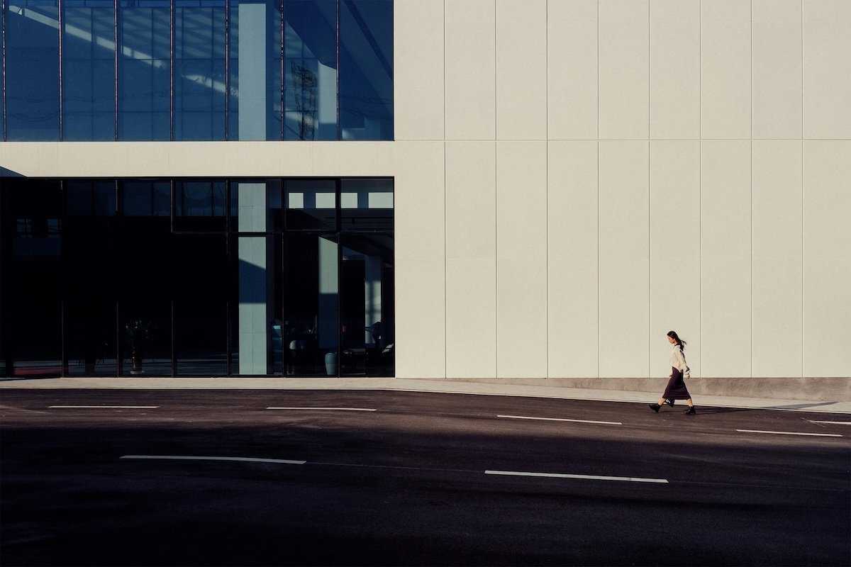 A street photo of a person walking in front of a building showing visual weight