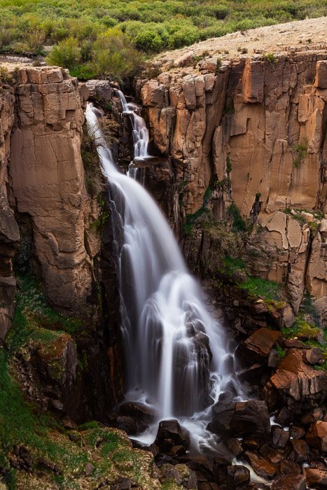 Image of a blurred waterfall on a sunny day to show best landscape photography settings with an ND filter