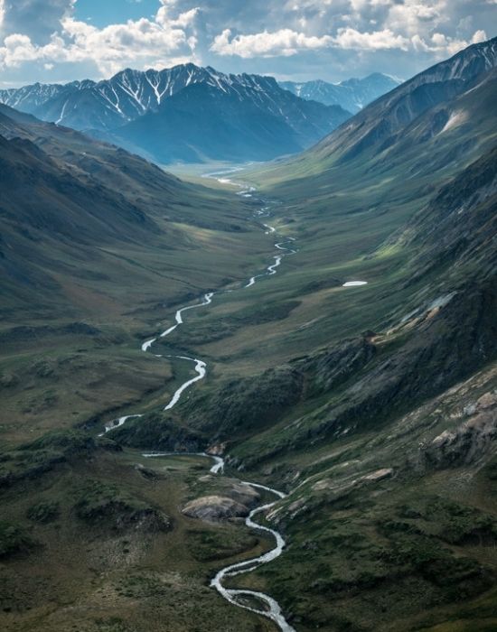 an aerial image of a river cutting through a valley