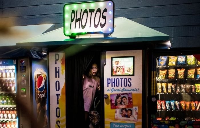 an image of a young girl sitting inside a classic photo booth