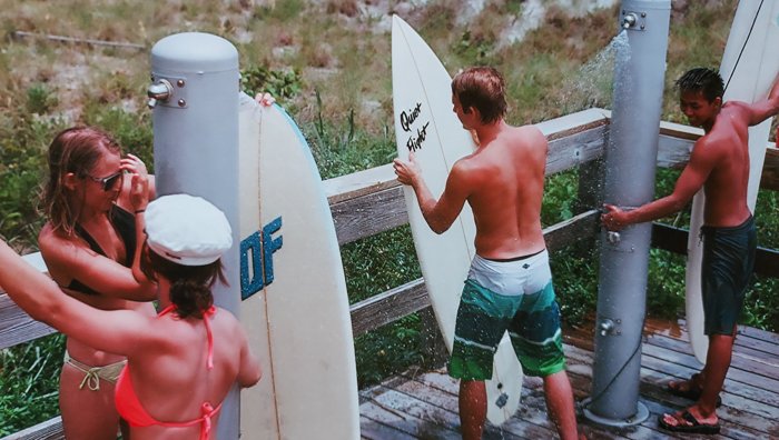 A group of surfers cleaning their surfboards
