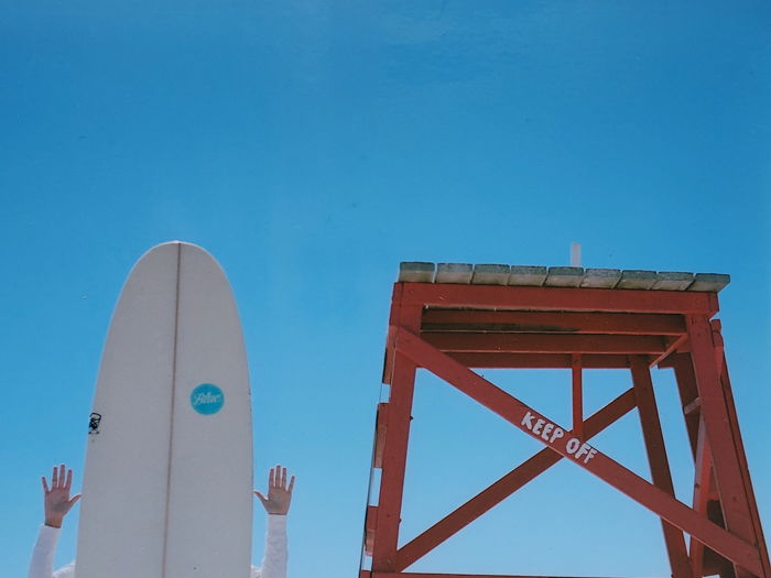 A surfer posing behind a surfboard