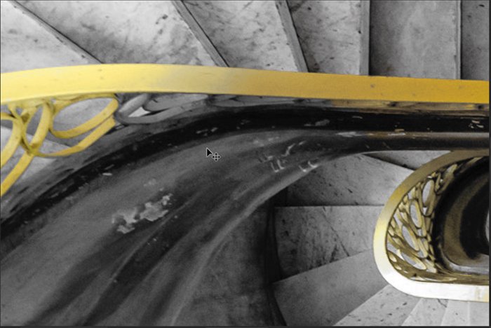 A detail of a spiral staircase with a yellow bannister for Photoshop selective color process