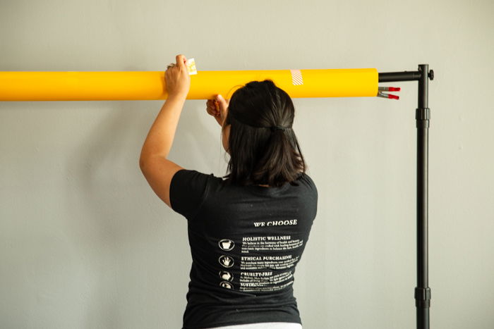 A woman setting up a background in the studio.