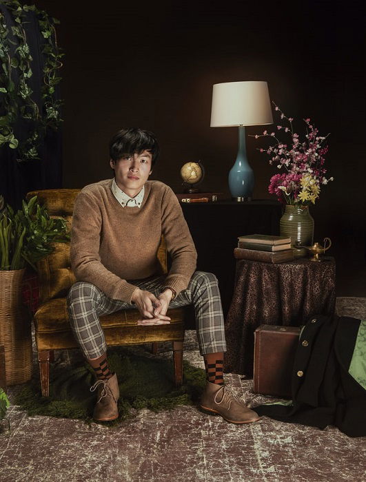 Fashionable and stylized studio portrait of a man sitting in a chair for editorial style photography