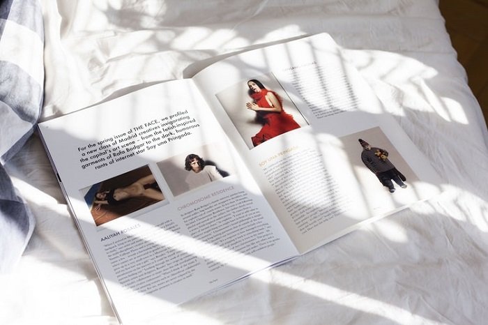 Magazine open on a bed showing an editorial photography spread