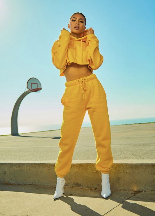 model wearing yellow athleisure fashion next to a basketball court