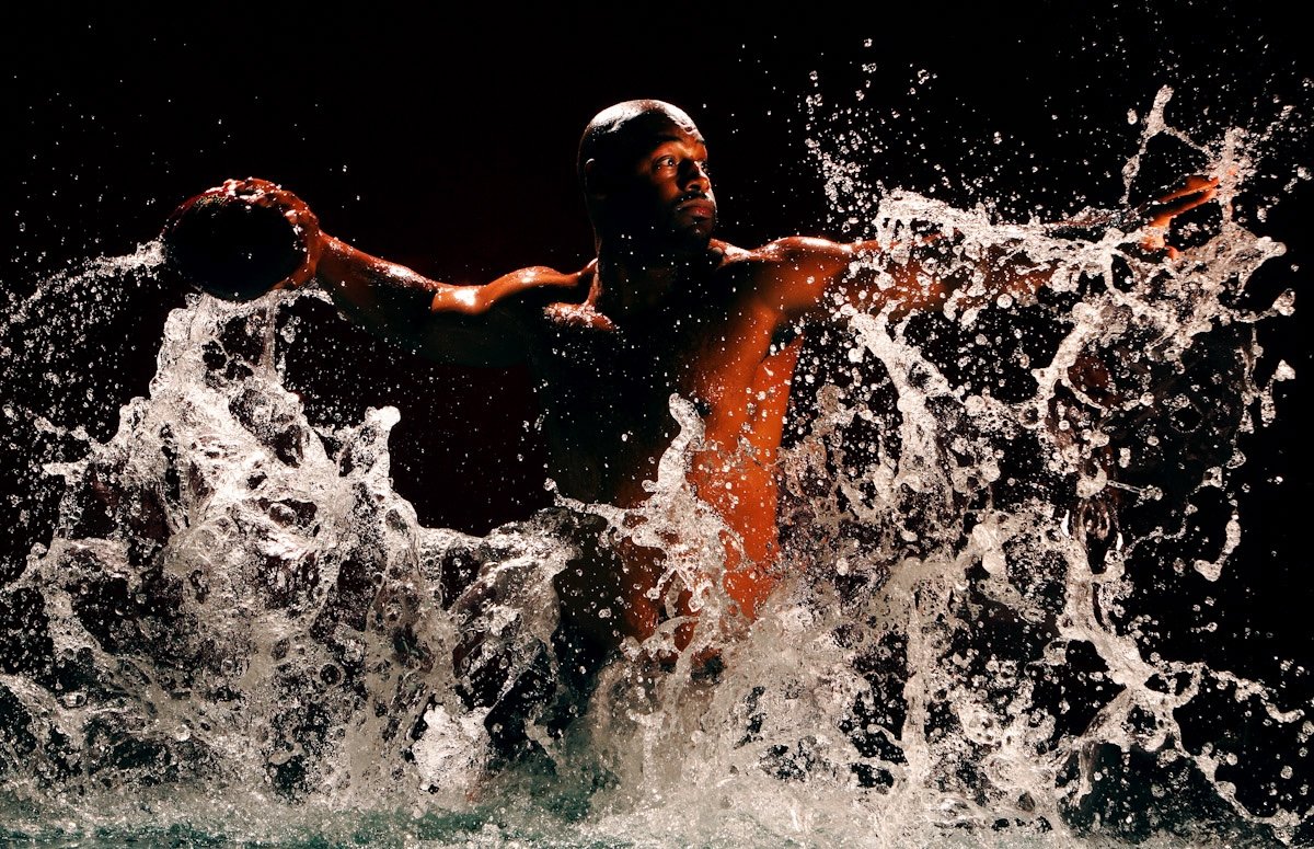 Portrait of an NFL quarterback throwing a football in water taken by one of the best sports photographers Al Bello