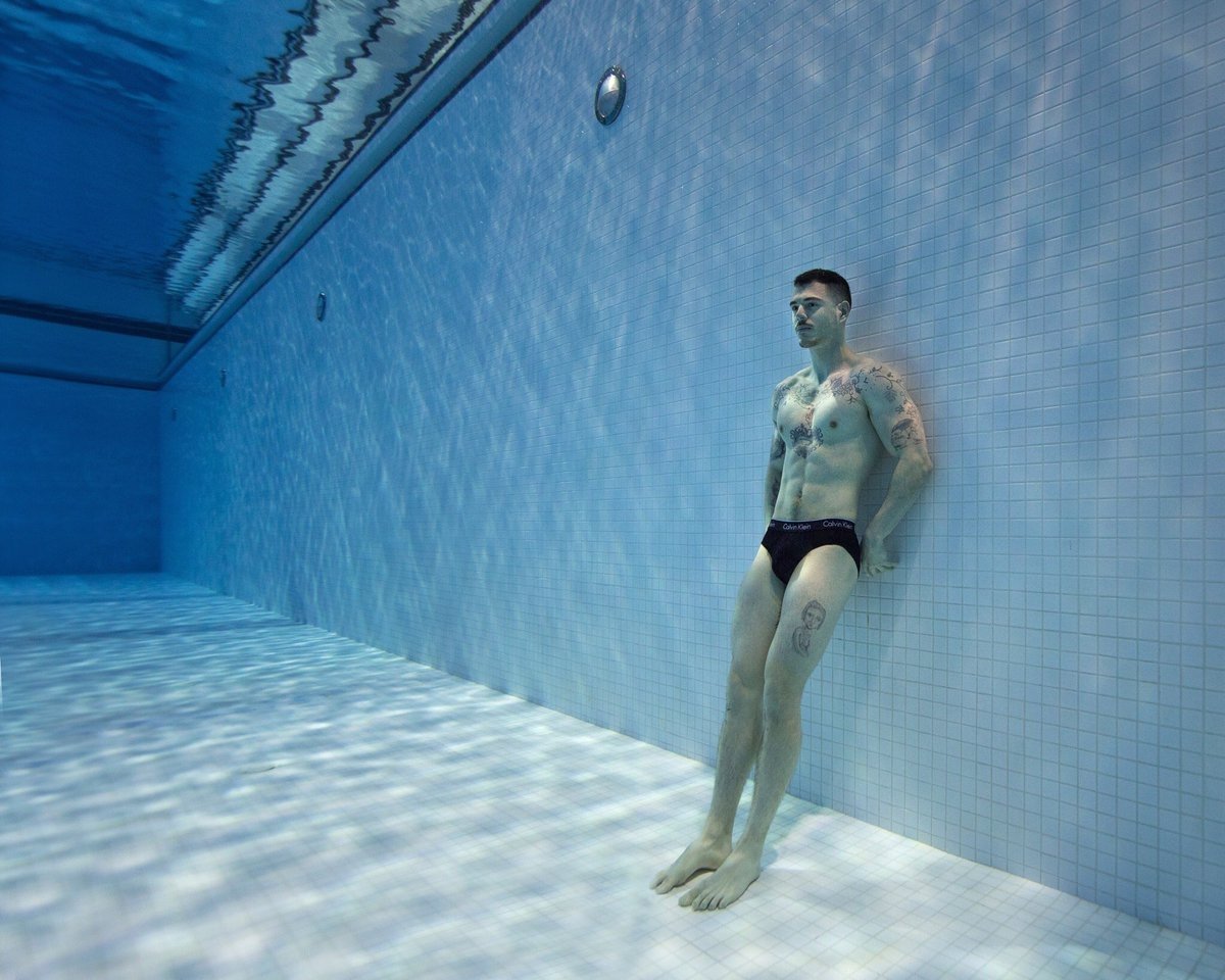 A swimmer standing at the bottom of a pool taken by one of the best sports photographers Lucas Murnaghan