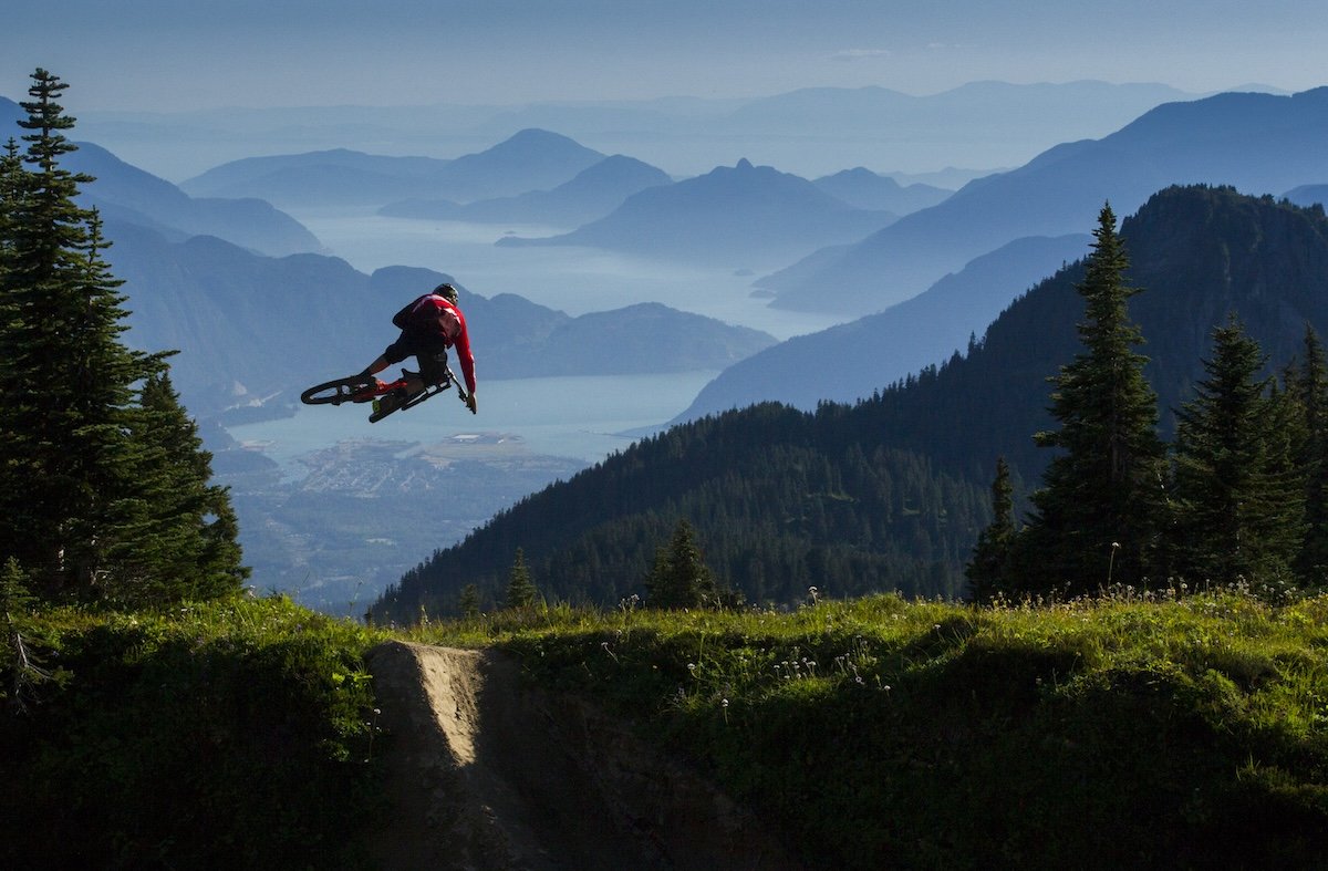 A mountain bike rider doing a trick in the air taken by one of the best sports photographers Sterling Lorence