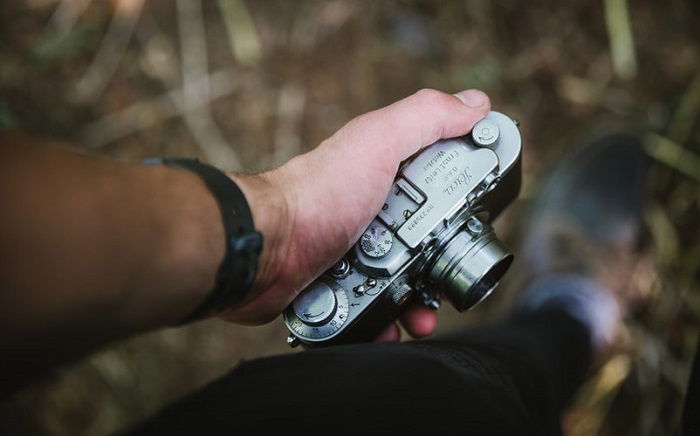 man holding a compact camera