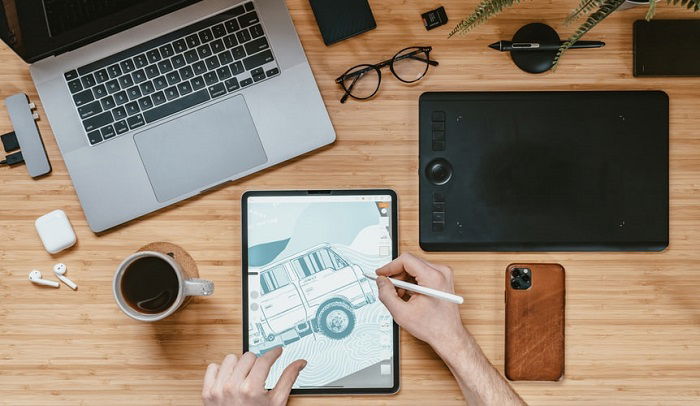 person drawing on a tablet on a desk