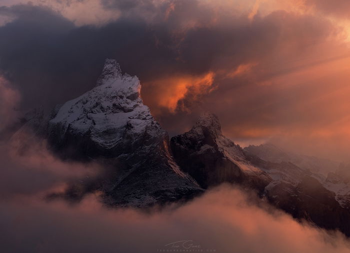 dramatic landscape photography: fog and clouds surround a snow-capped peak 