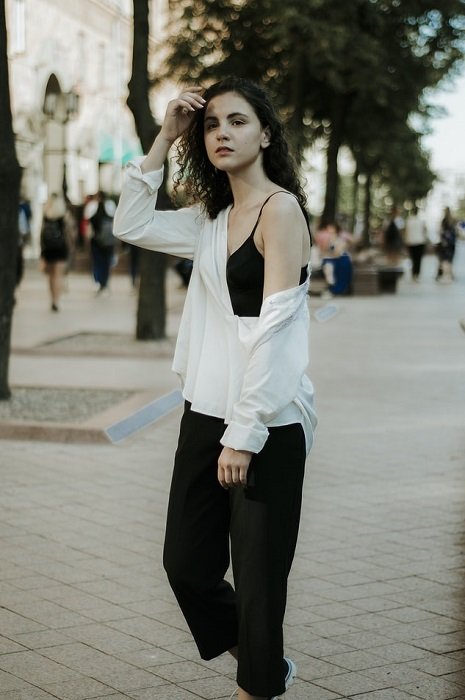 an image of a model posing on a sidewalk