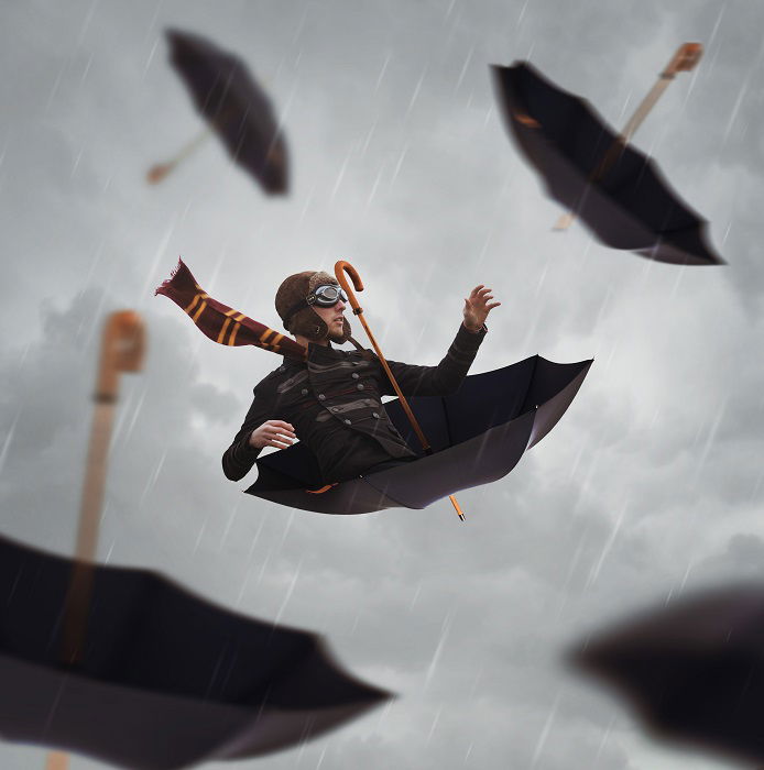 man nestled in an upside down umbrella floating in a grey sky