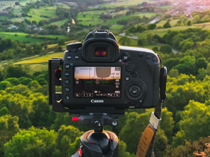 camera set up on a tripod looking out at a countryside landscape