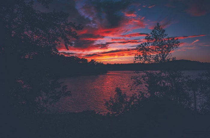 bright orange and red clouds over a dark sunset scene