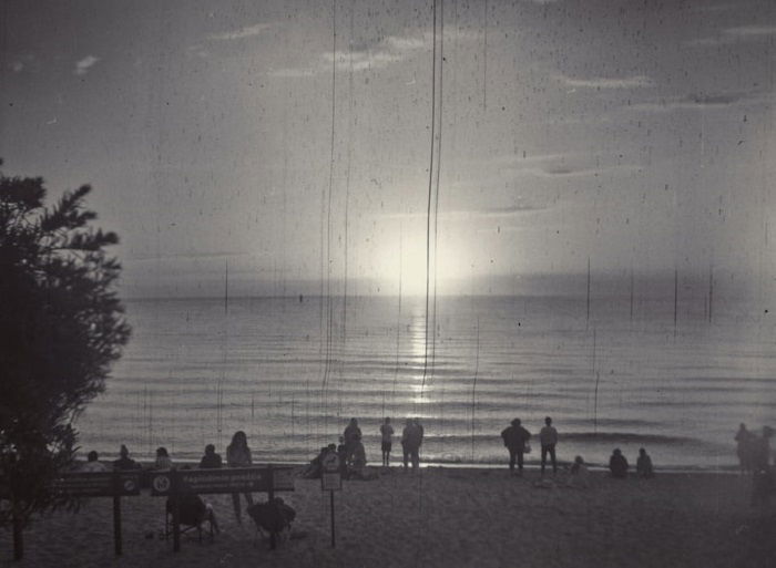 black and white film photograph of a seafront sunset