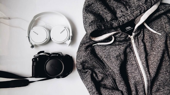 camera and headphones next to a grey jacket