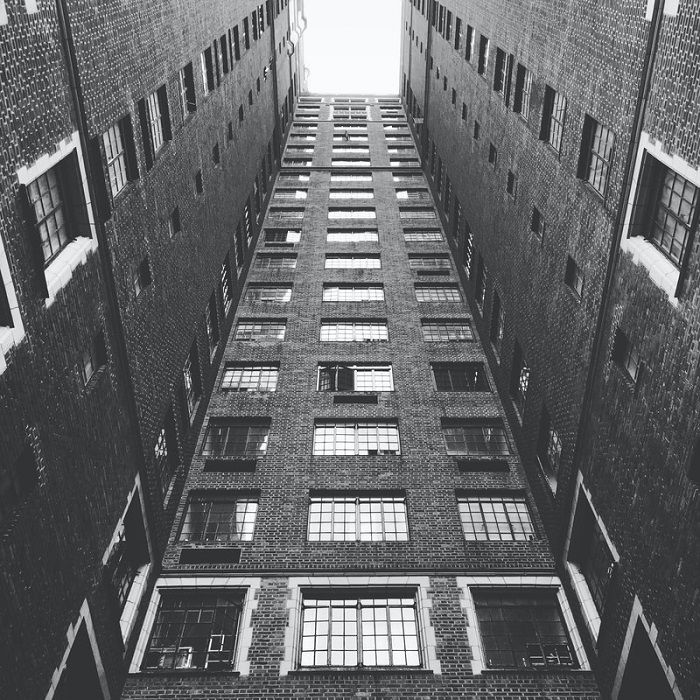 looking at the sky from the center of an apartment courtyard