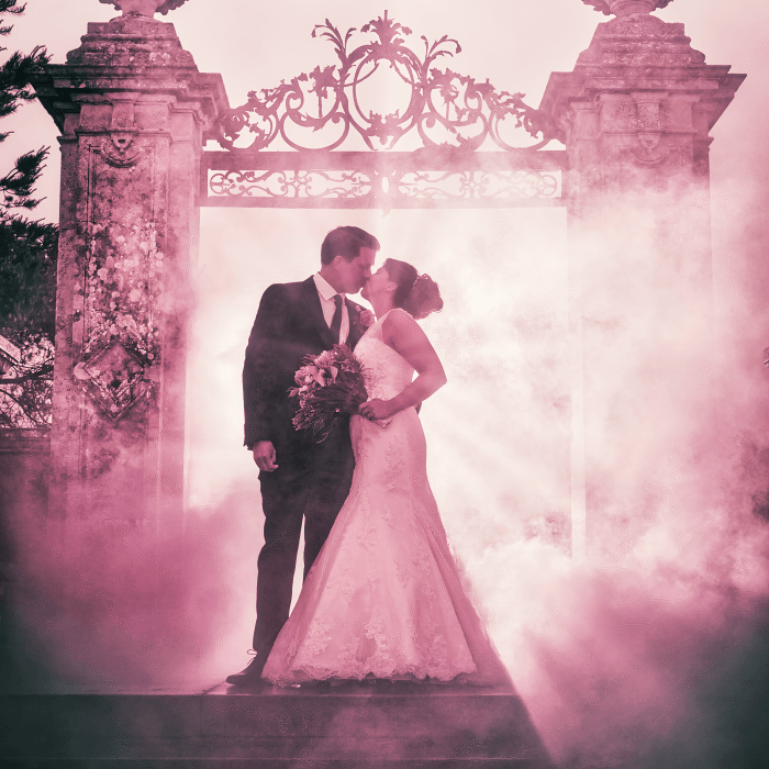 Couple Kissing in Pink Smoke with Backlight Flash on their Wedding Day