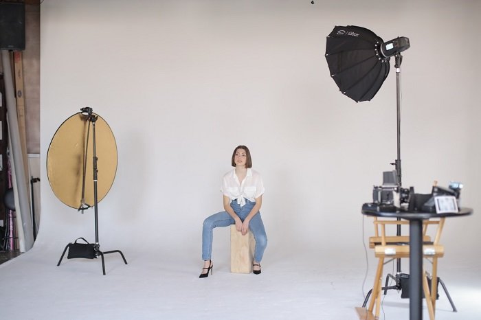 best photography backdrops: a woman waiting for her portrait in a photo studio setup