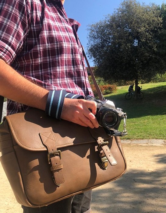 a photographer poses with his camera and Black Forest camera bag