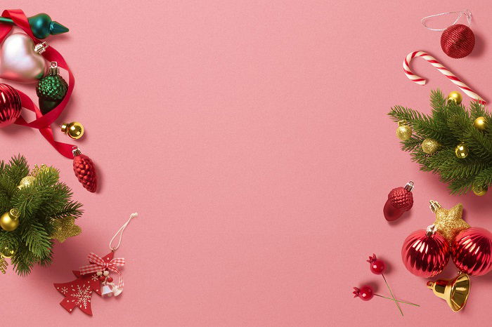 Christmas flat lay of decorations on pink background