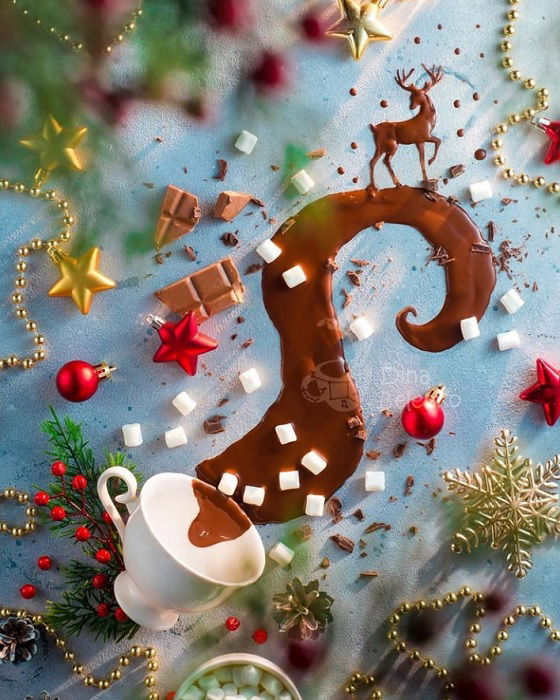 Christmas flat lay of decorations chocolate and sugar cubes coming out of a tea cup