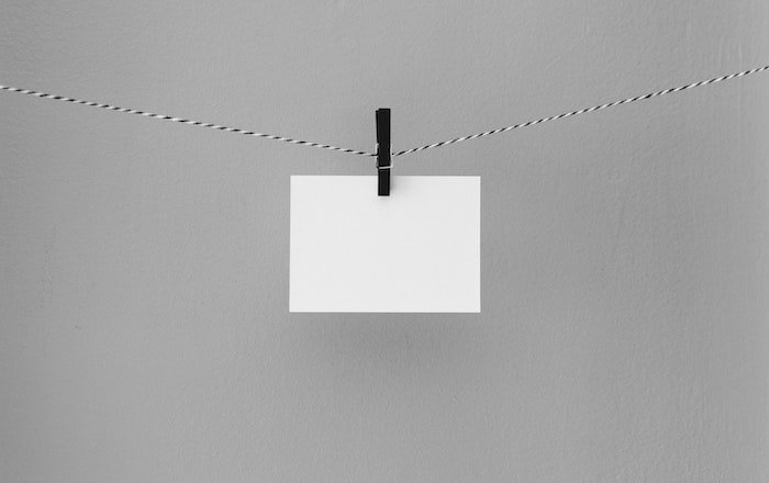 diy light reflector: A white card hanging on a clothesline by a clothespin