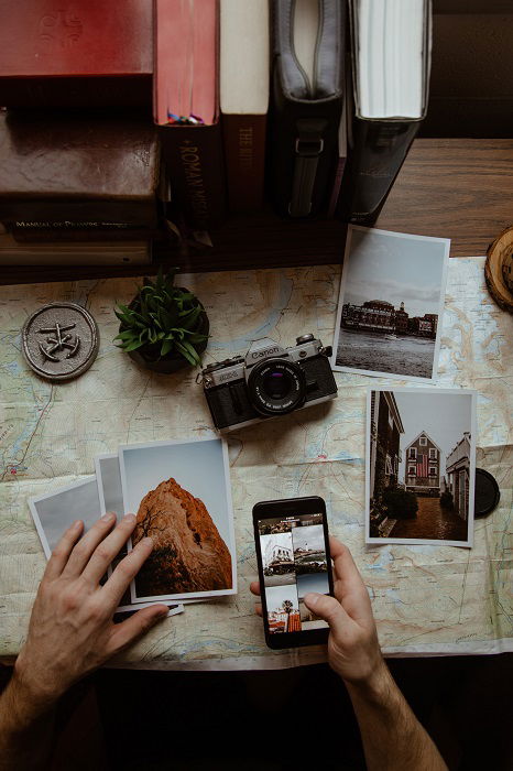 flat lay background idea: print photos and a camera lay atop a map