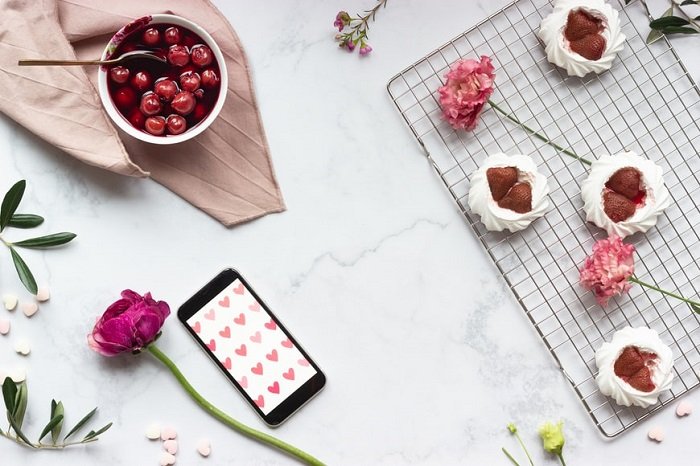 flat lay background idea: cherries, strawberries, and flowers on a marble countertop