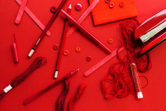 flat lay photography: pencils scattered on a red surface