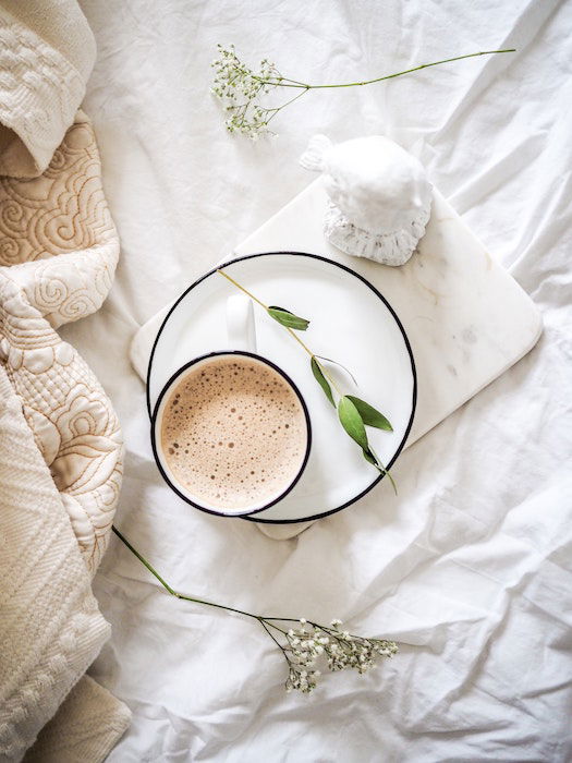 flat lay photo of a cup of coffee with flowers