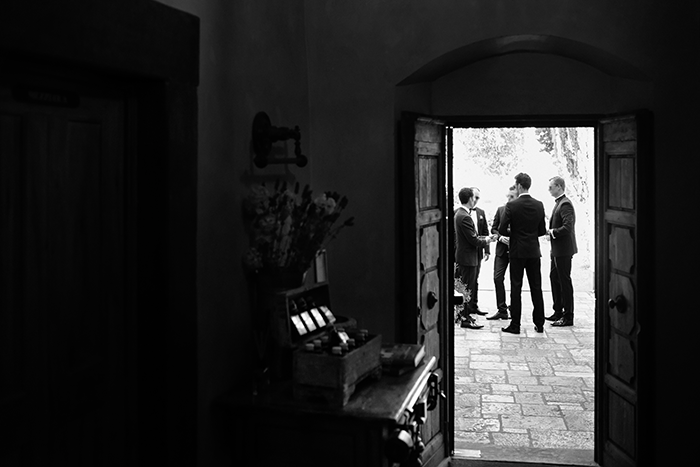 groomsmen picture idea: a black and white image of groomsmen framed in an old doorway