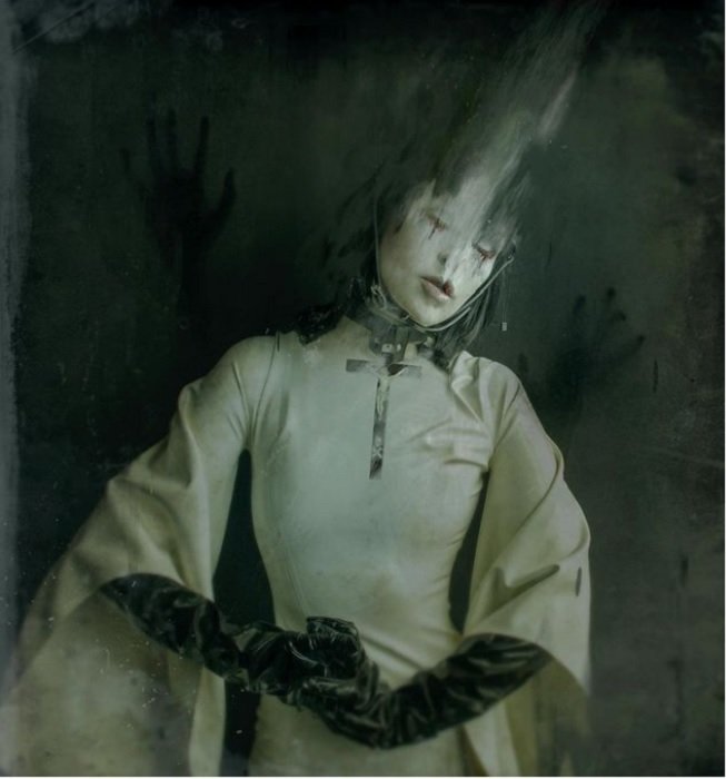 horror photography inspiration: a creepy woman with blurred hair dressed in white ceremonial garb and black gloves